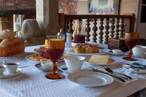 a table with plates of food and glasses on it at 1720 Quinta da Cancela - Winery & Farmhouse in Guimarães