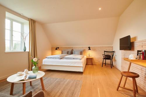 a bedroom with a bed and a table at Nordenholzer Hofhotel in Hude