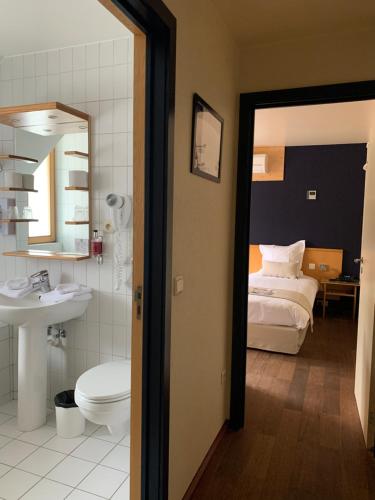 uma casa de banho com uma cama, um WC e um lavatório. em Auberge de Poteaupré em Bourlers