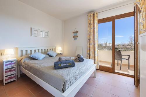 a bedroom with a bed and a balcony at Apartment Corb Mari in Port de Pollensa