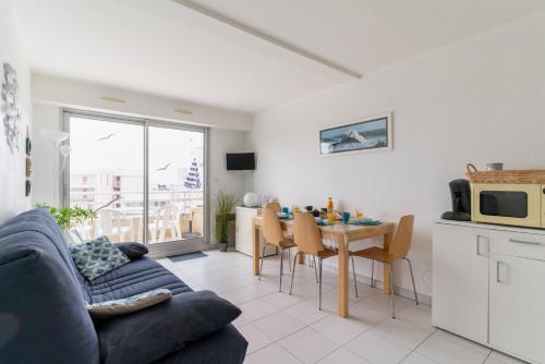 un salon avec un canapé bleu et une table dans l'établissement Oceane, à Pornichet