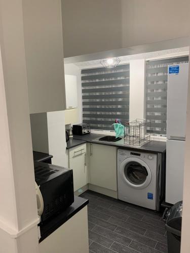 a kitchen with a washing machine and a microwave at 2 bed 1st floor Apartment-own entrance & parking in Portsmouth