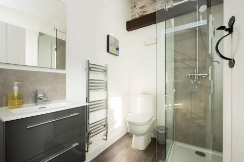 Un baño con inodoro y ducha de cristal. en The Cider House, en Sutton