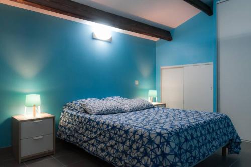 - une chambre bleue avec un lit et un mur bleu dans l'établissement L'Halevy- Appartement avec Garage proche gare et centre commercial Polygone Beziers- Wifi, à Béziers