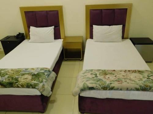 dwa łóżka siedzące obok siebie w pokoju w obiekcie Royal Castle w Rahimjar Khan