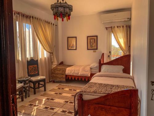 Royal Suite on The Touristic Promenade في الغردقة: غرفة نوم بسريرين وثريا