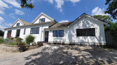 a white house with black windows and a driveway at Cosy 2-Bed Property in Ashburton Dartmoor in Newton Abbot