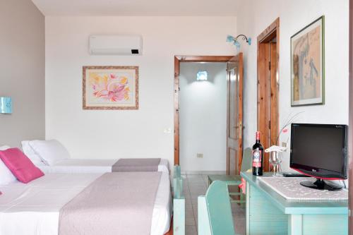 a bedroom with a bed and a desk with a computer at S'Enis Monte Maccione in Oliena