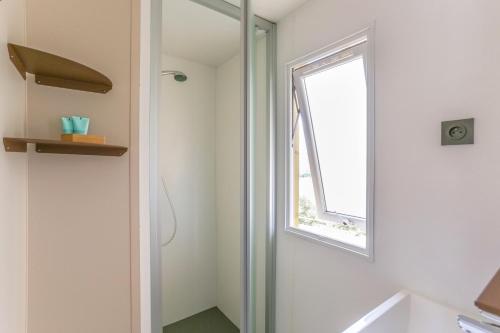 a bathroom with a shower and a window at Camping maeva Escapades Colomba in Olmeto
