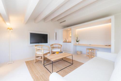 a white living room with a table and chairs at Yartan Boutique Hotel - Adults Only in Artá