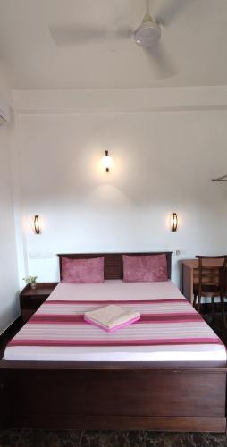 una camera da letto con un letto con una coperta rossa e bianca di Villa Rodrigo a Negombo