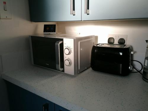 eine Küchentheke mit einer Mikrowelle und einem Toaster in der Unterkunft 7 beds sleeps 9 2 miles (7 mins) from Newcastle centre in Low Team