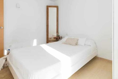 a large white bed in a white bedroom at Maravilloso apto de diseño a 1 minuto de la playa in Cala Santandria