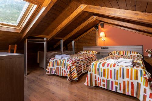a room with two beds in a attic at Apartamentos Casa Roldan I in Benasque
