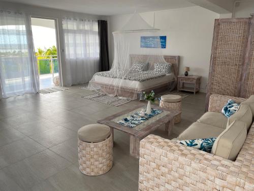 a living room with a bed and a couch and a table at Morne Side Apartments in La Gaulette