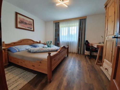 ein Schlafzimmer mit einem Holzbett und einem Schreibtisch. in der Unterkunft Ferienwohnung Stillerhof in Innsbruck
