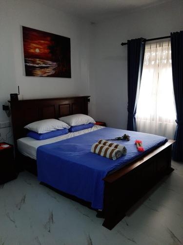 a bedroom with two beds with blue sheets and a window at Villa Talpe in Talpe
