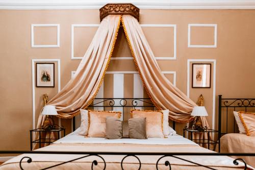 a bedroom with a canopy bed with pillows at Foresteria di Palazzo Picedi - Historic Rooms Sarzana in Sarzana