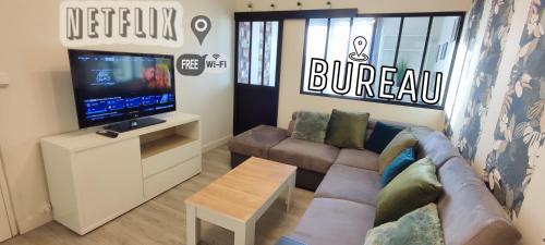 sala de estar con sofá y TV de pantalla plana en T4 Massy TGV by Beds4Wanderlust - 80m2 avec Terrasse et bureau - proche coulée verte - idéal Pro ou Famille, en Massy