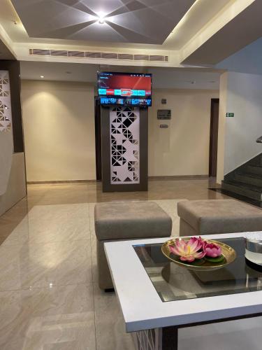 a living room with a table and a tv on the wall at Dash Hotels - Affordable Luxury in Hyderabad