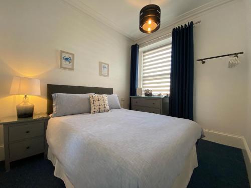a bedroom with a large bed and a window at Rooms At Babbacombe in Torquay