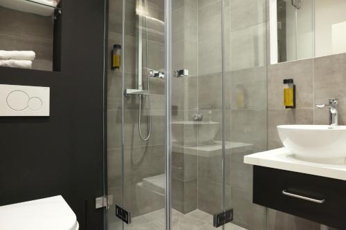 W łazience znajduje się prysznic i umywalka. w obiekcie JustStay Solingen w mieście Solingen