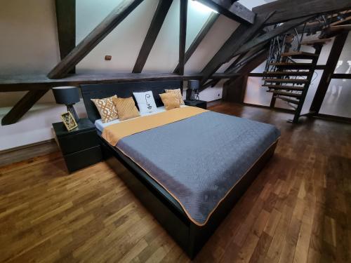 - une chambre avec un grand lit en mezzanine dans l'établissement Galerie Vila Lucia 5 -Loft apartmán, à Plzeň