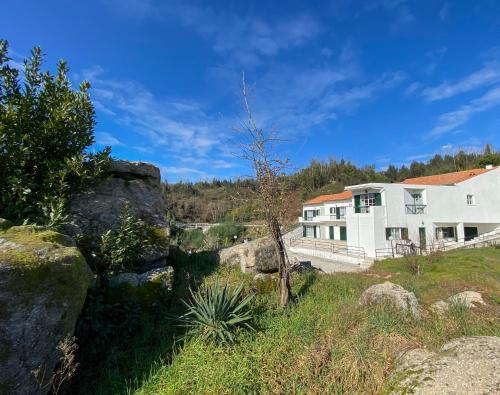 a house on the side of a river with rocks at Encosta do Sol in Canas de Senhorim