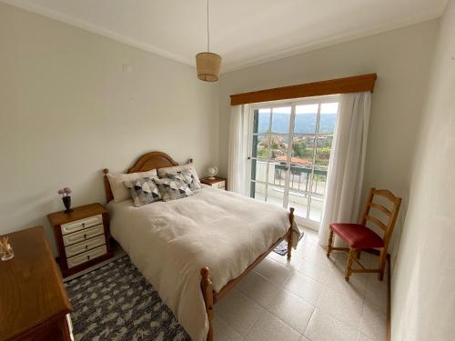 a bedroom with a bed and a large window at Encosta do Sol in Canas de Senhorim