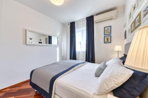a bedroom with a large bed and a window at Blumarine Apartments in Dubrovnik