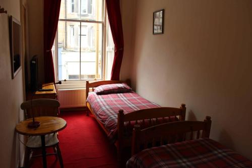 two beds in a room with a window at Argyle Backpackers in Edinburgh