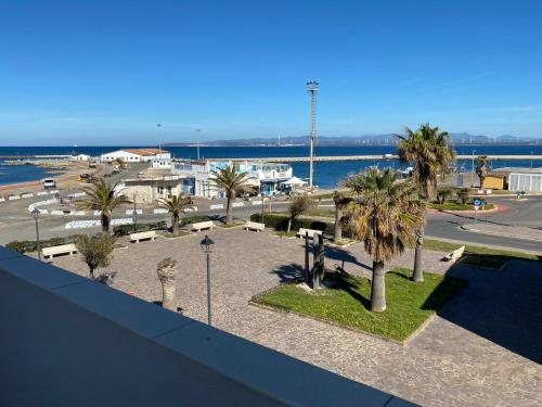 a view of a park with palm trees and the ocean at Attici con Terrazzo vista Mare in Calasetta