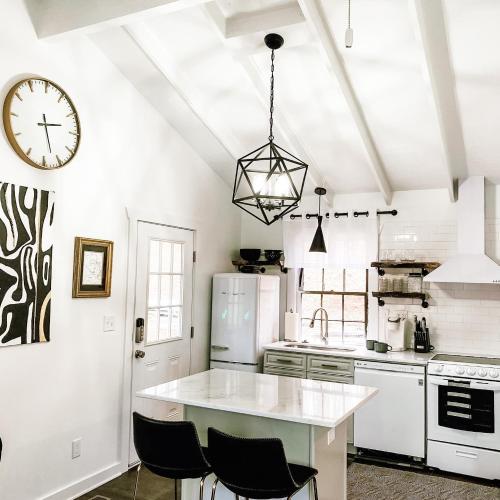 a kitchen with white appliances and a clock on the wall at Mountain Retreat Nesteled in the Virginia Foothills in Charlottesville