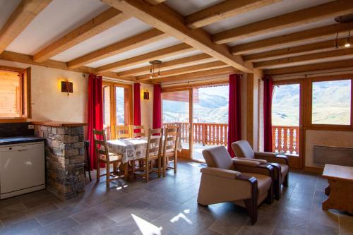 a living room with a fireplace and a table and chairs at Bouquetin Appartements VTI in Val Thorens