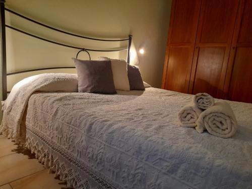 a bedroom with a white bed with towels on it at Casa Giampiero in Villaputzu