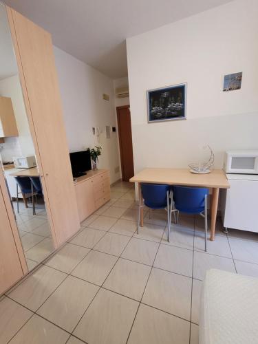 a kitchen and dining room with a table and blue chairs at Casa Lucia Centro Apartment Deluxe in Sottomarina