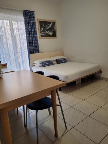 a room with a bed and a desk and a bed and a table at Casa Lucia Centro Apartment Deluxe in Sottomarina