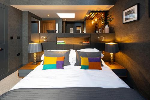 ein Schlafzimmer mit einem großen Bett mit bunten Kissen in der Unterkunft Roselea Cottage in Luss