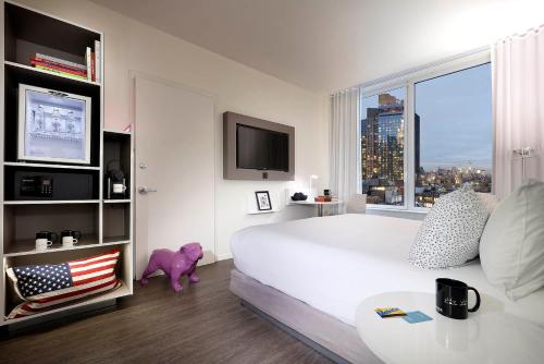 a bedroom with a large white bed and a large window at INNSiDE by Meliá New York Nomad in New York