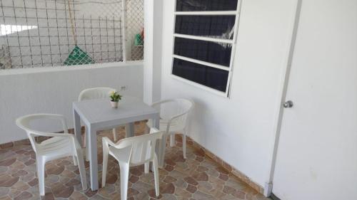 un piccolo tavolo bianco con sedie in una stanza di Sarie Bay Inn a San Andrés