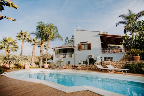 une villa avec une piscine en face d'une maison dans l'établissement Villa Dorotea con piscina, à Trappeto