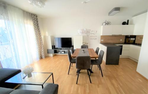 a living room with a table and chairs and a kitchen at Wein Kultur Apartment Flavia Solva in Wagna