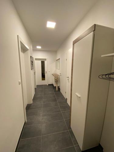 a hallway with white walls and a tile floor at Wein Kultur Apartment Flavia Solva in Wagna
