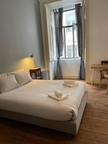 a bedroom with a bed with two towels on it at Azulejos Cais Sodré B&B in Lisbon