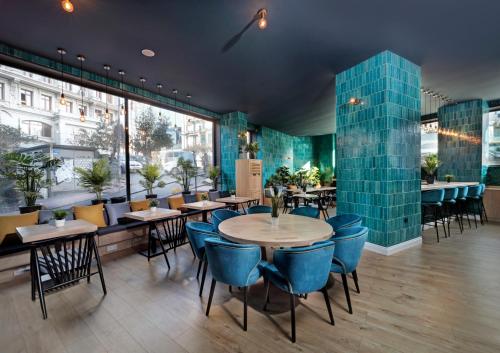 restauracja ze stołami i krzesłami oraz dużym oknem w obiekcie The Central House Istanbul Galata w Stambule