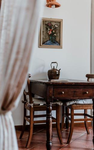 a room with a table and a vase of flowers at Cascina Delle Rose in Barbaresco