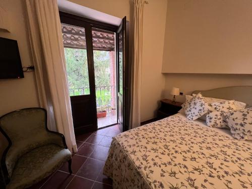 a bedroom with a bed and a chair and a window at Il Casale di Riardo Luxury B&B in Riardo