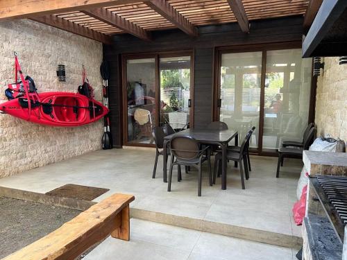 un patio con una mesa y un kayak rojo en la pared en PUCON HOUSE - Lake Access & Near Ski Center, en Pucón