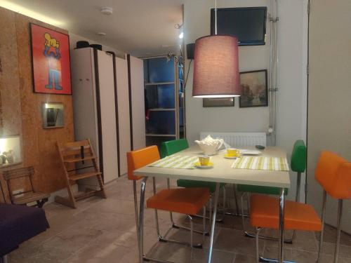a dining room with a table and orange chairs at Studio53Amsterdam in Amsterdam