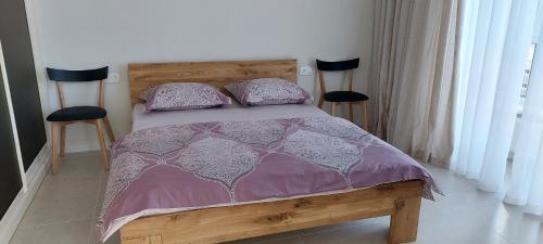 a bedroom with a bed with a purple comforter and two chairs at Апартаменти в ЖК Гранд Бурже подобово in Bucha